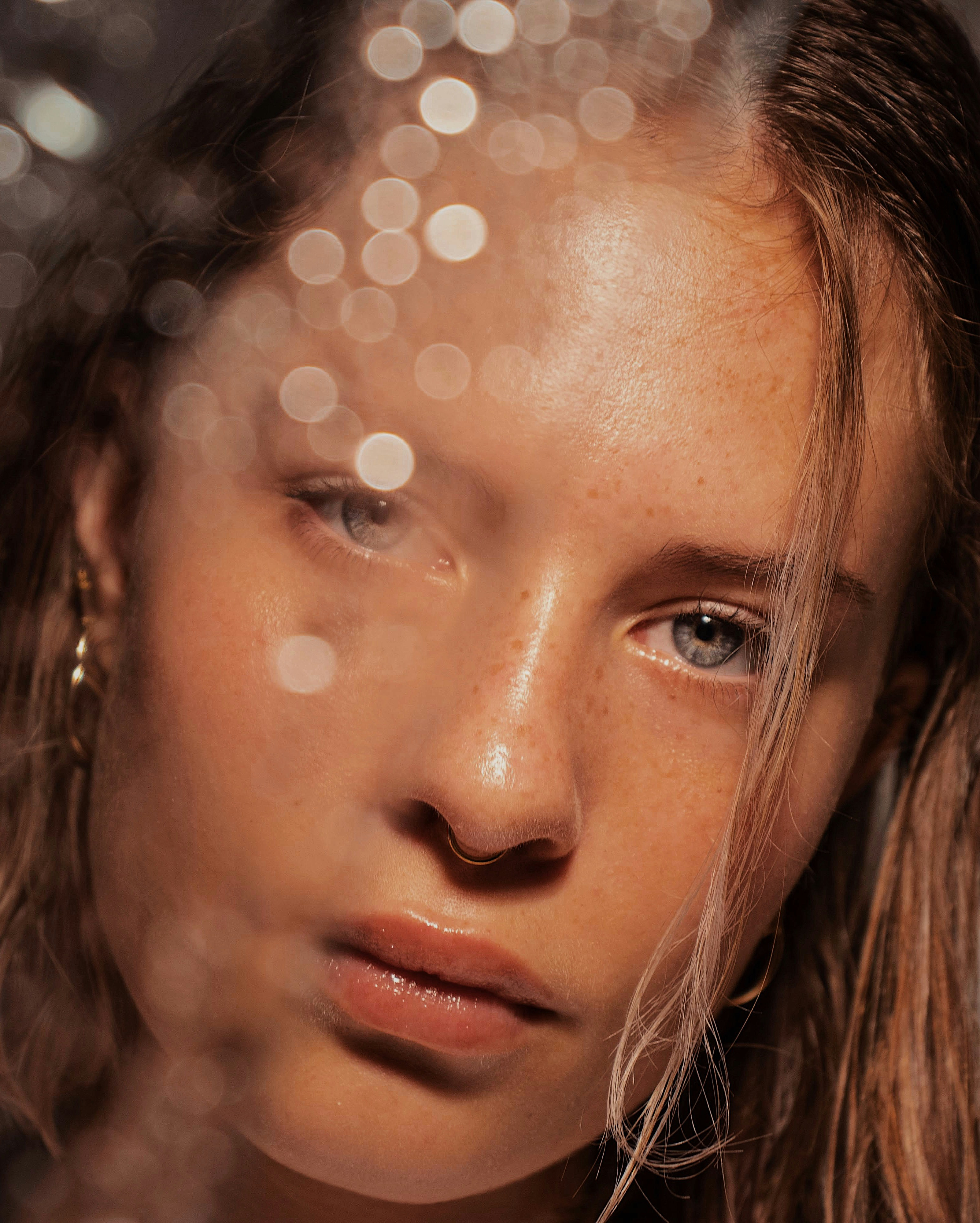 Close-up of a woman's face with natural skin and bokeh light