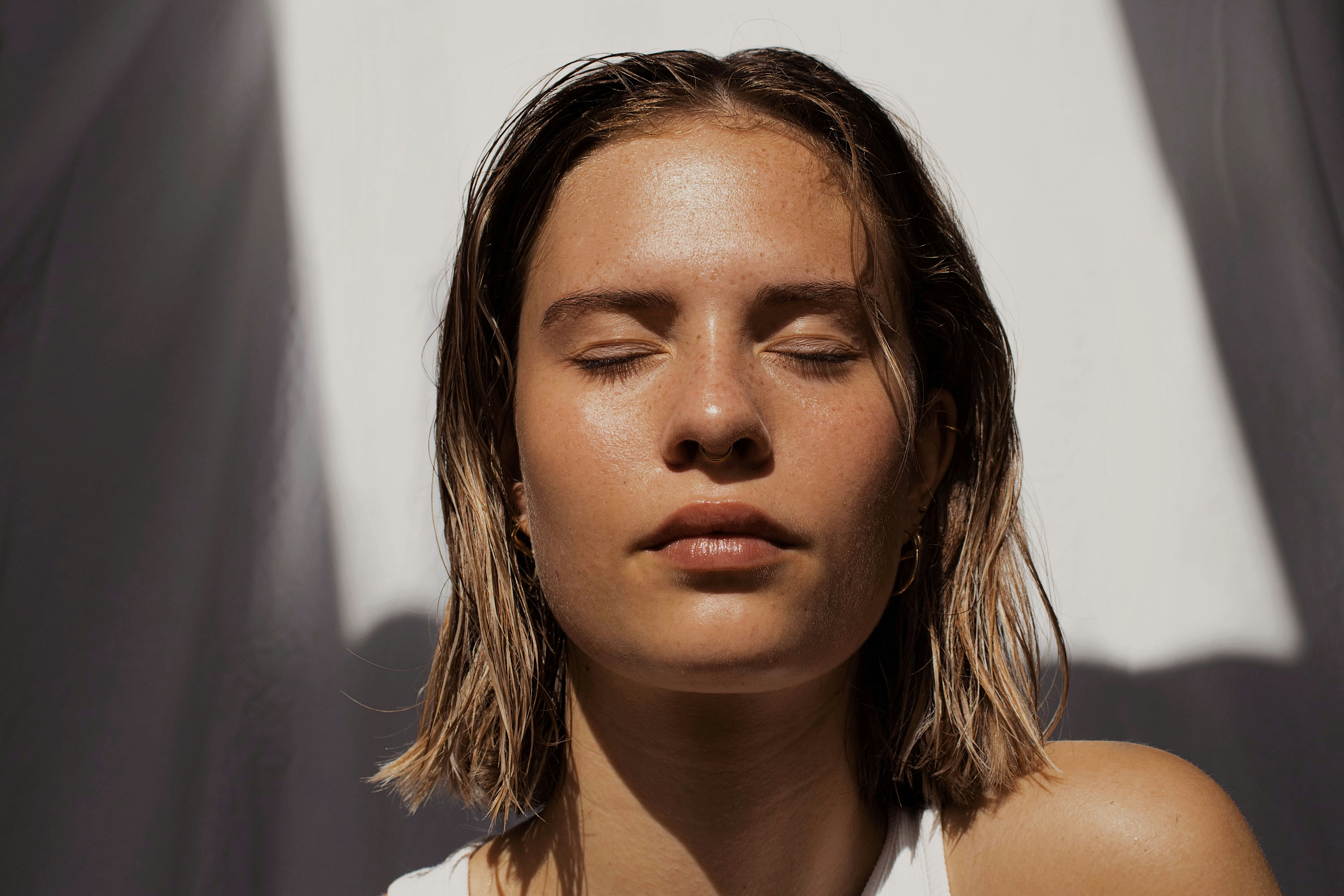 Woman with closed eyes, natural bare skin in sunlight