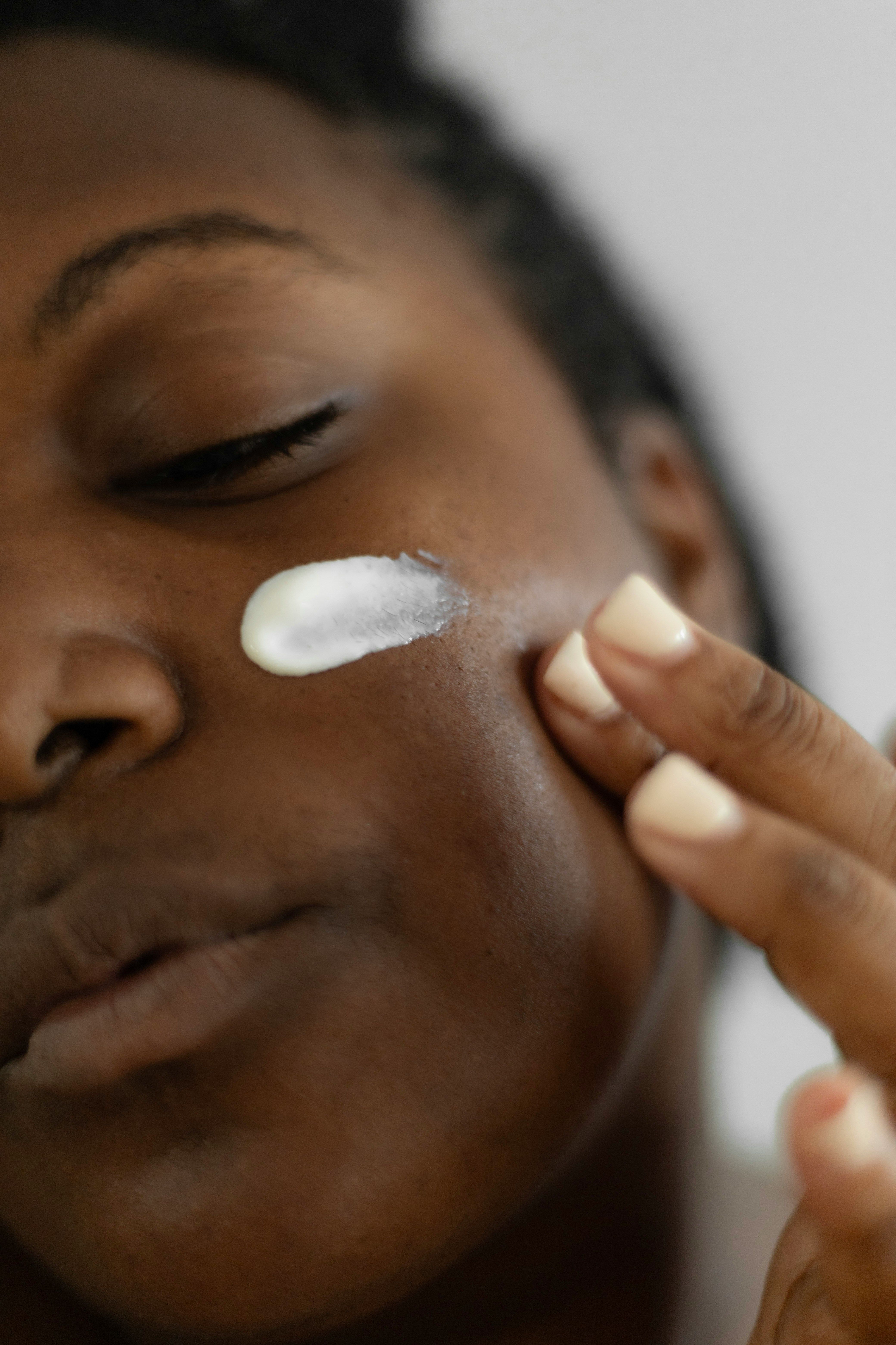 Close-up of moisturiser being applied to a cheek